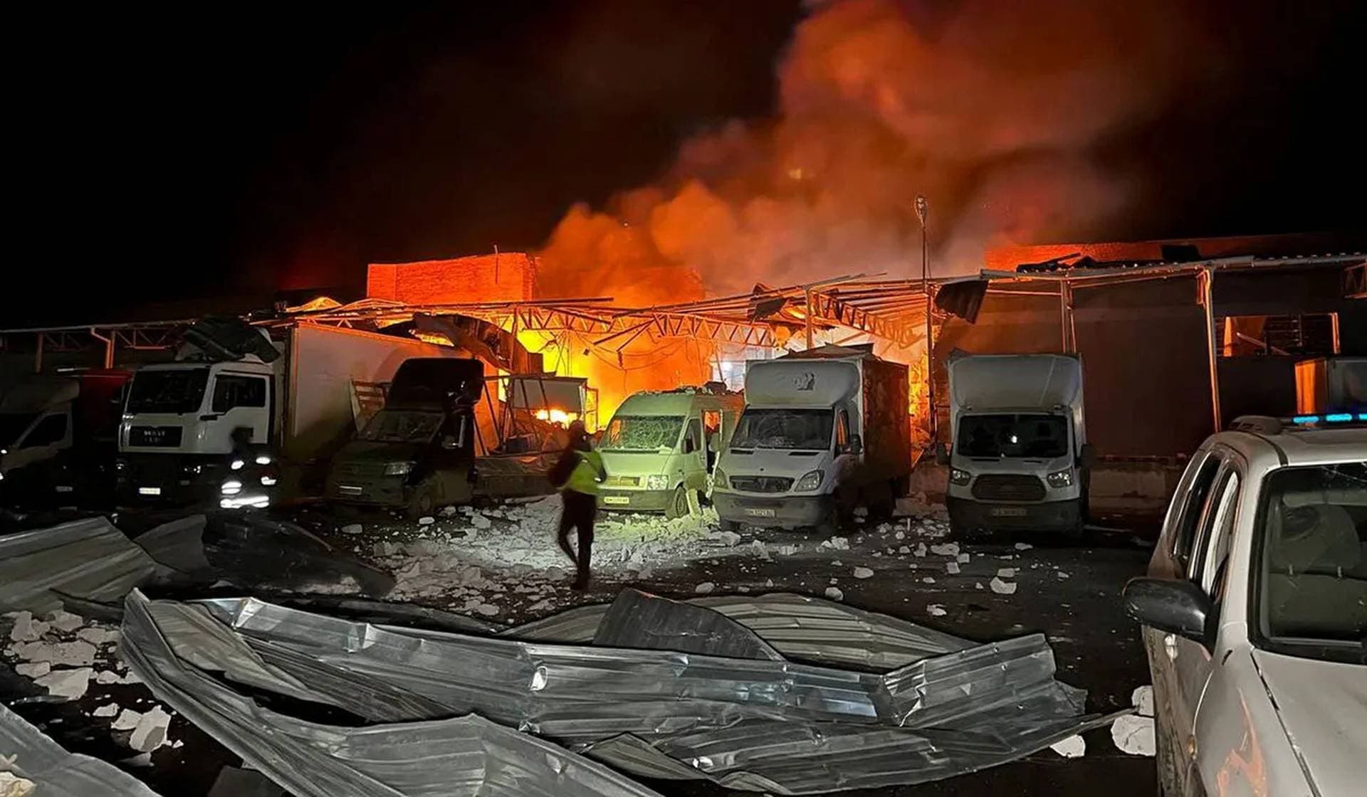 A police officer walks at the site of a warehouse hit by a Russian drone strike in Sumy