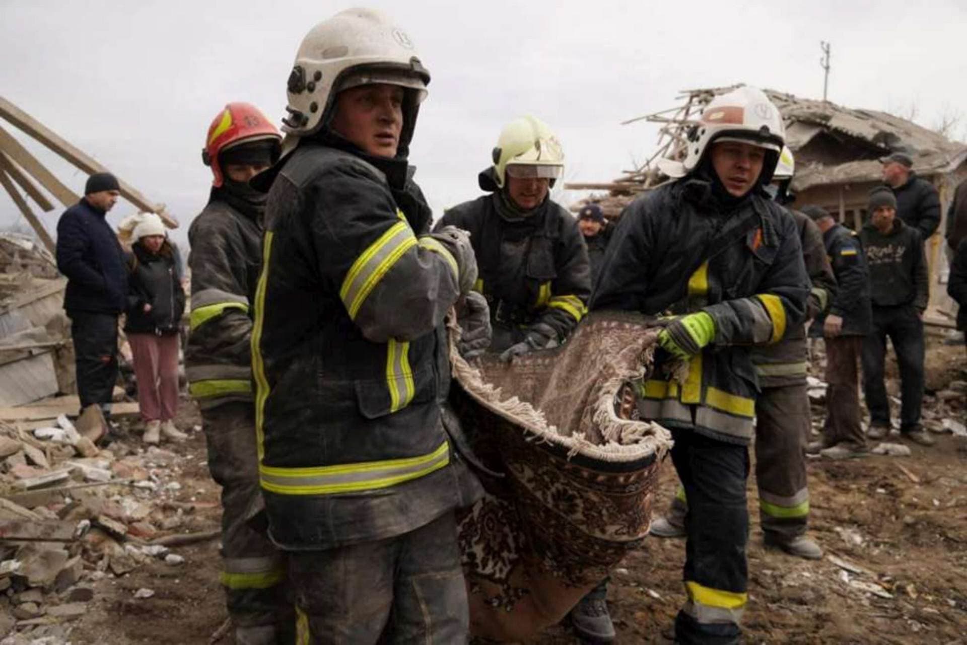 Rescue workers look for survivors amid the rubble of a residential building that was hit by a Russian missile strike in the western city of Lviv