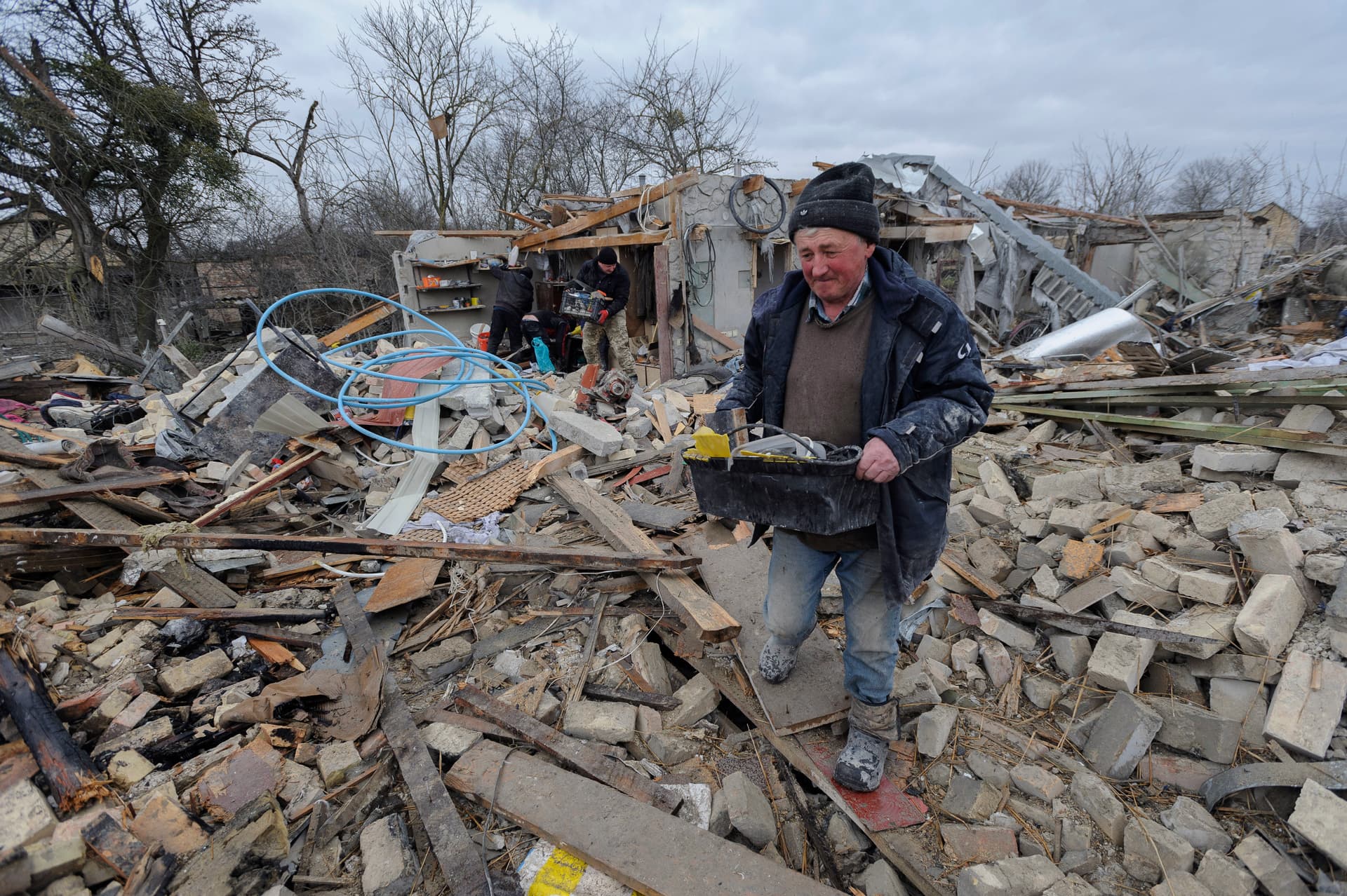 Villagers clear the rubble after Russia's night rocket attack ruined private houses in a village, in Zolochevsky district
